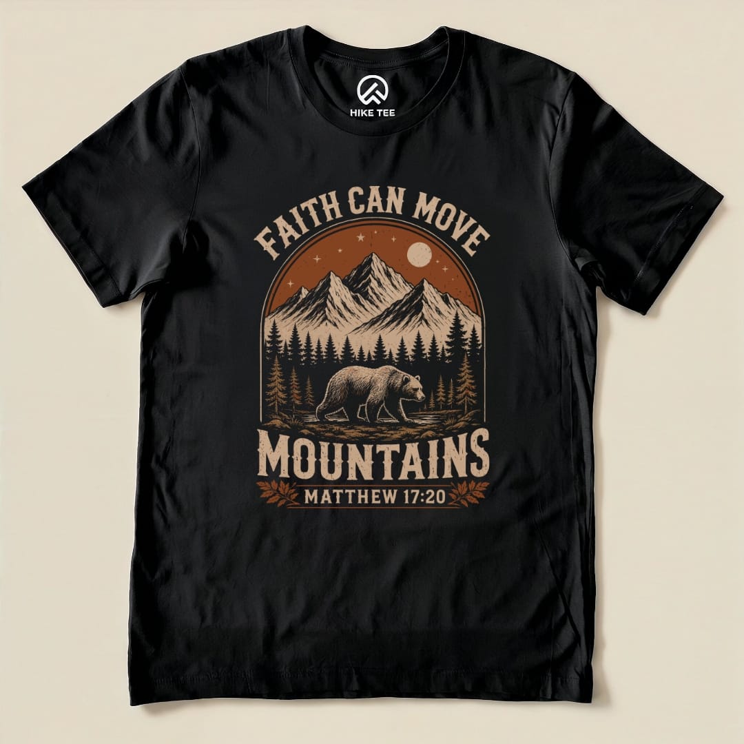 A black graphic t-shirt featuring the slogan "Faith Can Move Mountains" above a bear and mountain scene, with "Matthew 17:20" below.