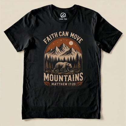 A black graphic t-shirt featuring the slogan "Faith Can Move Mountains" above a bear and mountain scene, with "Matthew 17:20" below.
