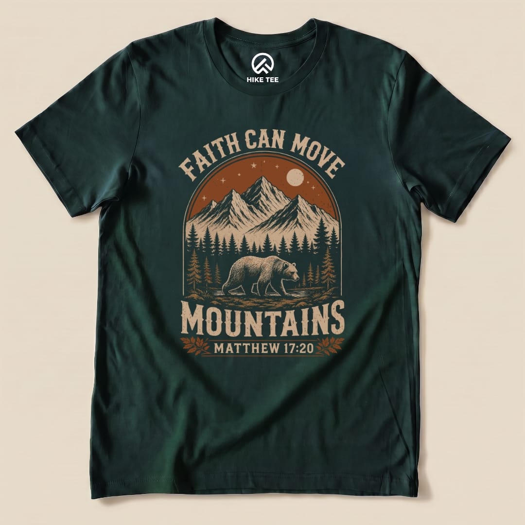 A dark green graphic t-shirt featuring the phrase "Faith Can Move Mountains" with a scenic mountain design and a bear.