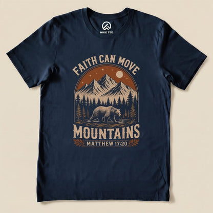A dark navy graphic t-shirt featuring the phrase "Faith Can Move Mountains" above an illustration of mountains, trees, and a bear.