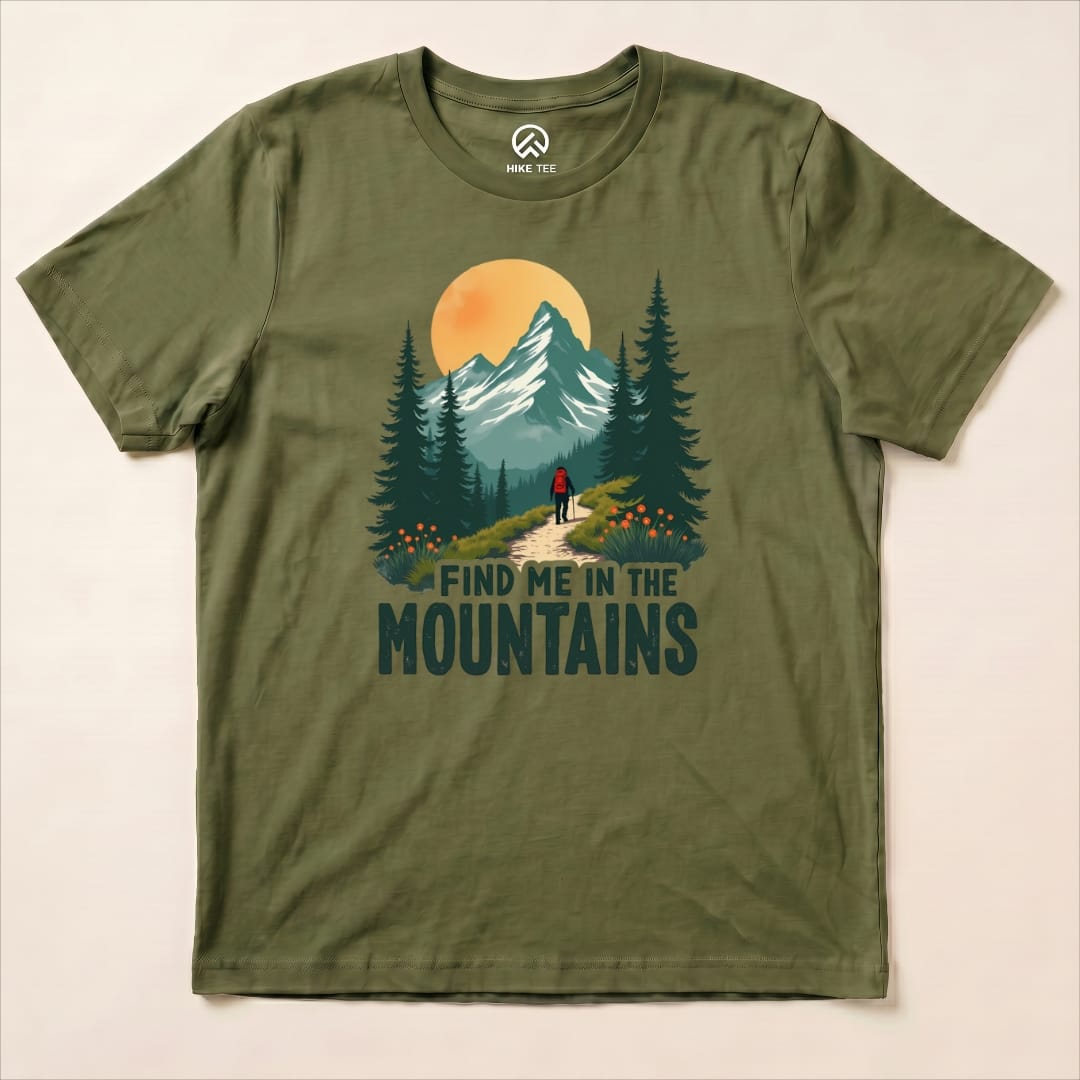 The olive green graphic t-shirt displays a hiker walking on a trail with the text "FIND ME IN THE MOUNTAINS" beneath a mountain scene.