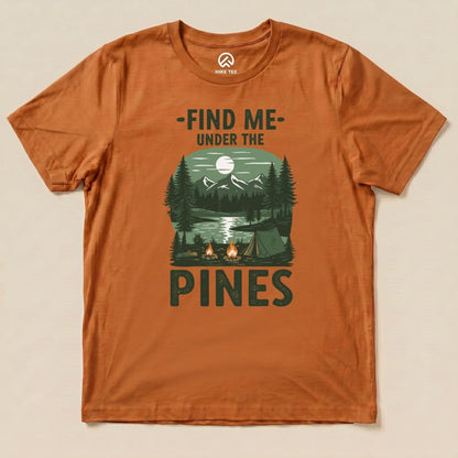 The orange graphic t-shirt features an outdoor scene with a lake, mountains, and pine trees, topped by the phrase "Find Me Under The Pines Shirt.