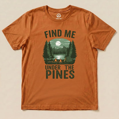 The "Find Me Under The Pines Shirt" features a serene camping scene with trees, a lake, and a mountain backdrop in earthy tones.