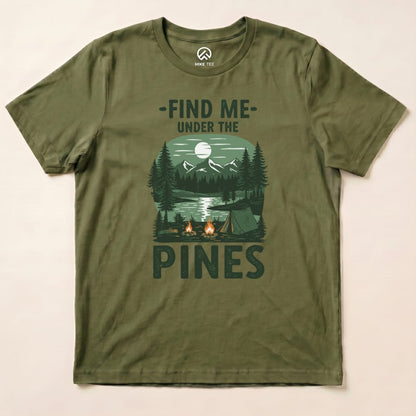 The olive green graphic t-shirt features a scenic design with the words "Find Me Under The Pines" above a forest and campsite.