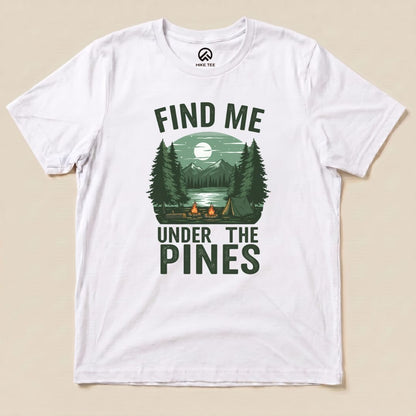A white graphic t-shirt features the slogan "Find Me Under The Pines" with a scenic design of trees, mountains, and a lake.