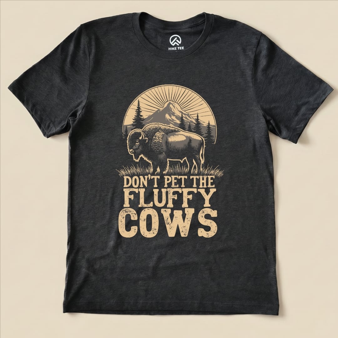 The Fluffy Cow Shirt features a graphic of a bison with the slogan "DON'T PET THE FLUFFY COWS" above a mountain scene.