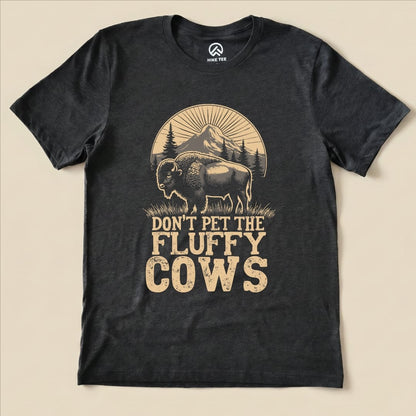 The Fluffy Cow Shirt features a graphic of a bison with the slogan "DON'T PET THE FLUFFY COWS" above a mountain scene.