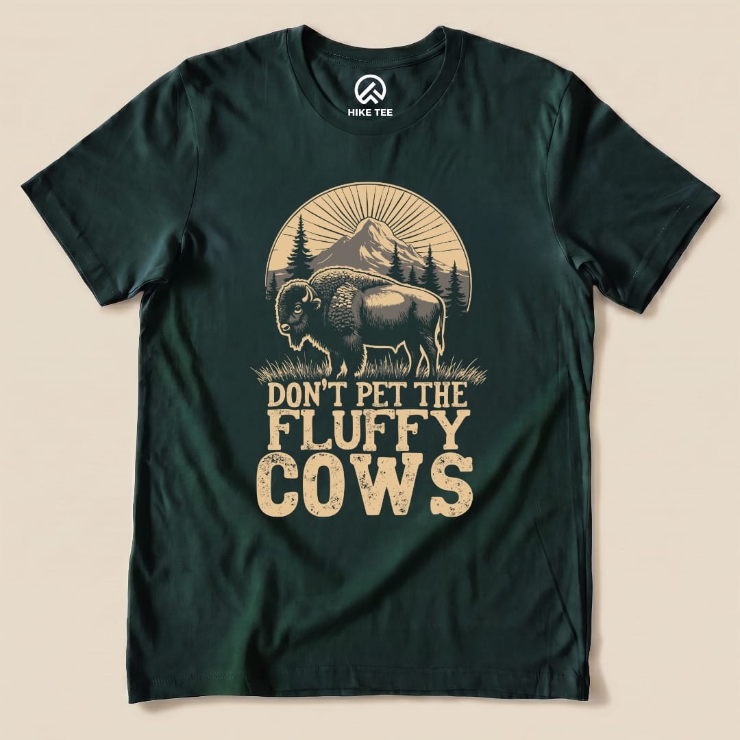 A dark green graphic t-shirt featuring a bison illustration and the text "DON'T PET THE FLUFFY COWS.