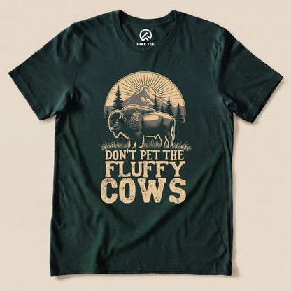 A dark green graphic t-shirt featuring a bison illustration and the text "DON'T PET THE FLUFFY COWS.