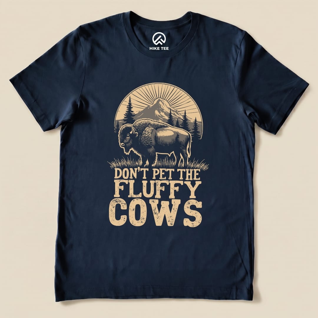 A navy graphic t-shirt features a bison and the phrase "Don't Pet the Fluffy Cows" with mountains in the background.