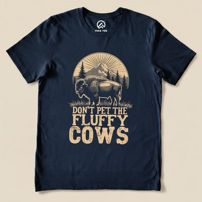 A navy graphic t-shirt features a bison and the phrase "Don't Pet the Fluffy Cows" with mountains in the background.