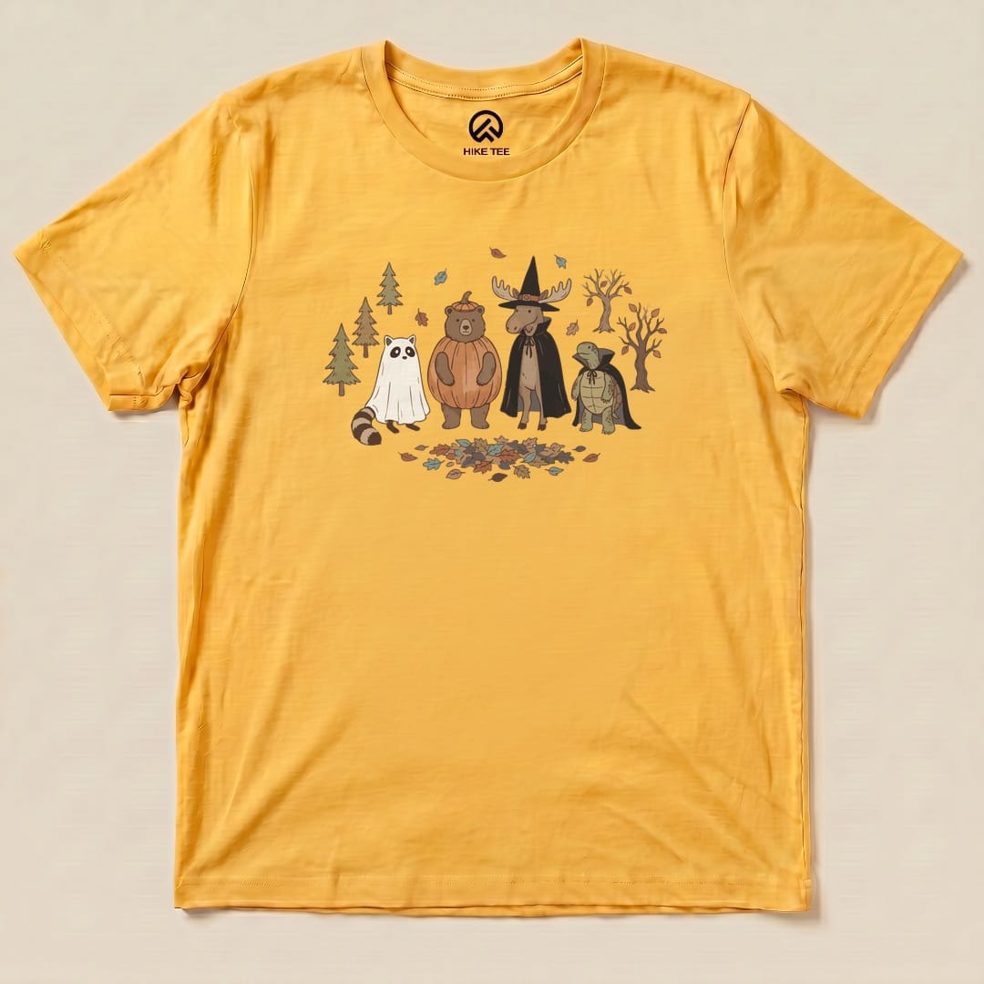A graphic t-shirt featuring cartoon animals, including a bear and a raccoon, dressed for a "Forest Friends Costume Party Shirt.