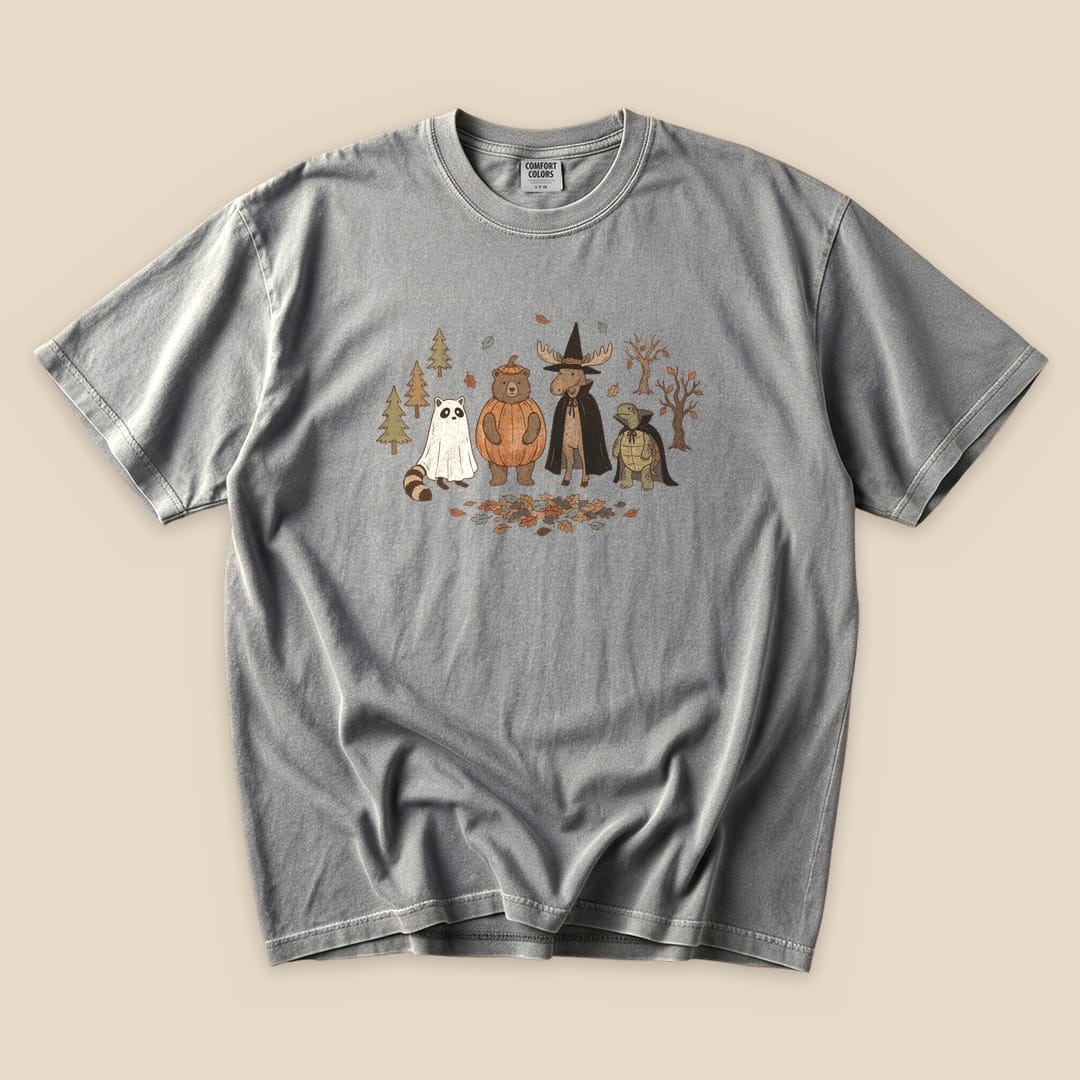 A graphic t-shirt featuring woodland animals in costumes, titled "Forest Friends Costume Party T-Shirt," on a gray background.