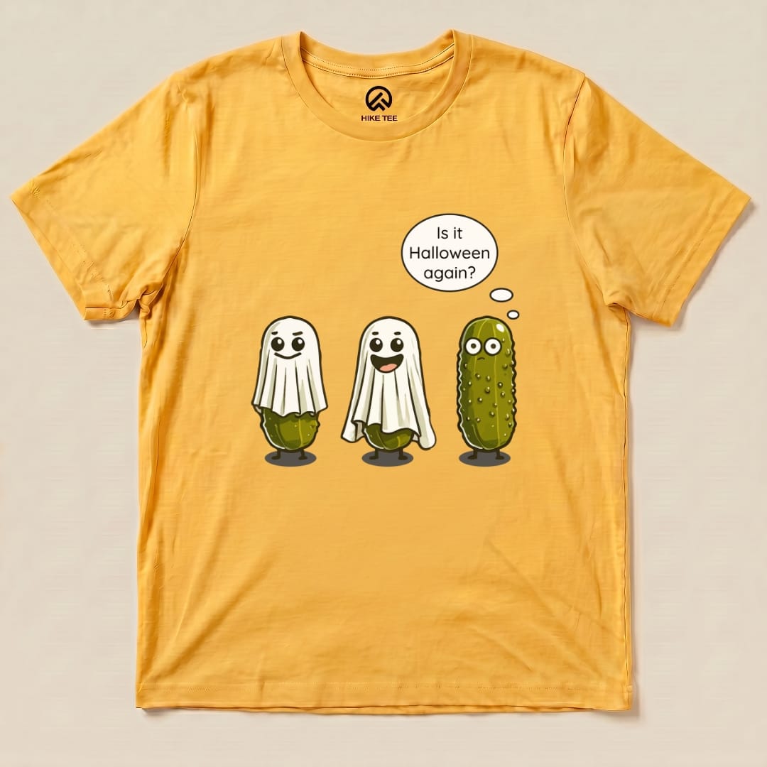A graphic t-shirt featuring two ghostly figures and a pickle, with the phrase "Is it Halloween again?" on a yellow background.