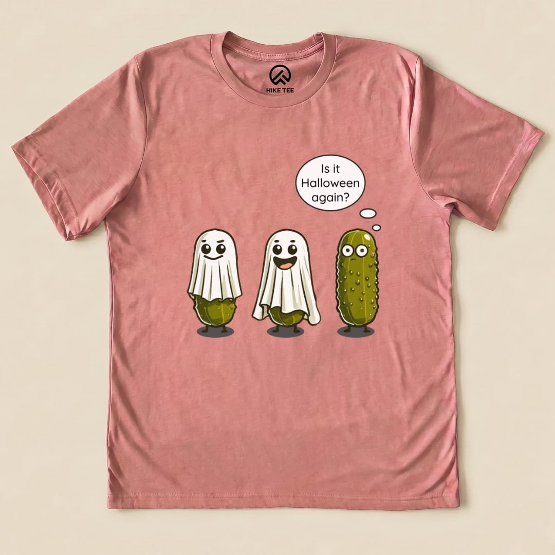 A pink graphic t-shirt featuring a Funny Pickle Ghost Shirt design with three ghostly pickles and the speech bubble, "Is it Halloween again?