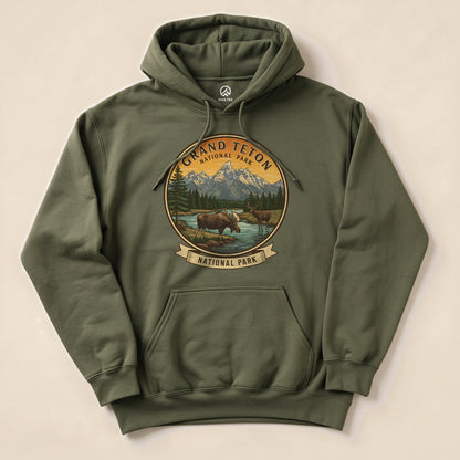 A graphic hoodie featuring the "Grand Teton Moose Hoodie" design, showcasing two moose by a river in Grand Teton National Park.