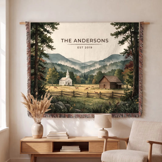 A cozy living space features a "Great Smoky Mountains Cades Cove Woven Blanket" displayed with a scenic mountain landscape.