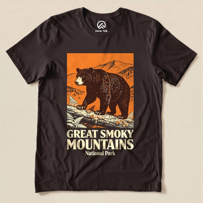A graphic t-shirt featuring a bear walking on a log with the text "Great Smoky Mountains National Park" prominently displayed.