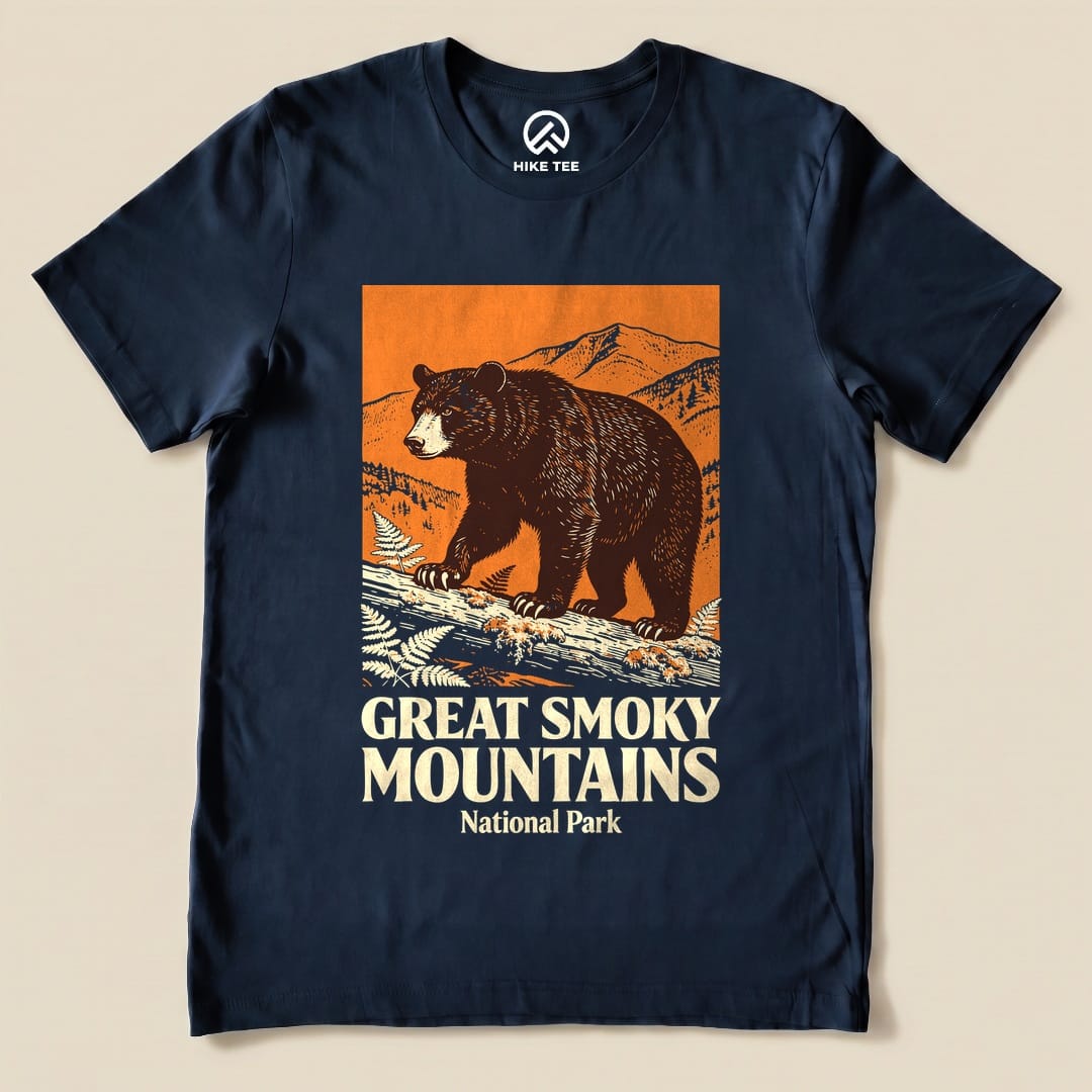 A navy graphic t-shirt features a bear walking on a log with mountains in the background, labeled "Great Smoky Mountains National Park Shirt.