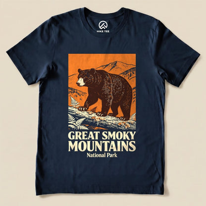 A navy graphic t-shirt features a bear walking on a log with mountains in the background, labeled "Great Smoky Mountains National Park Shirt.