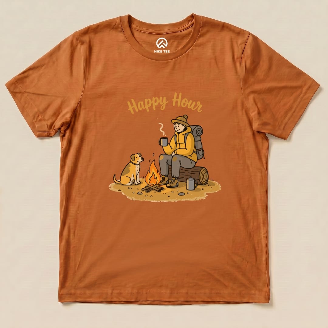 Graphic t-shirt featuring a person sitting by a campfire with a dog, captioned "Happy Hour" in a playful design.