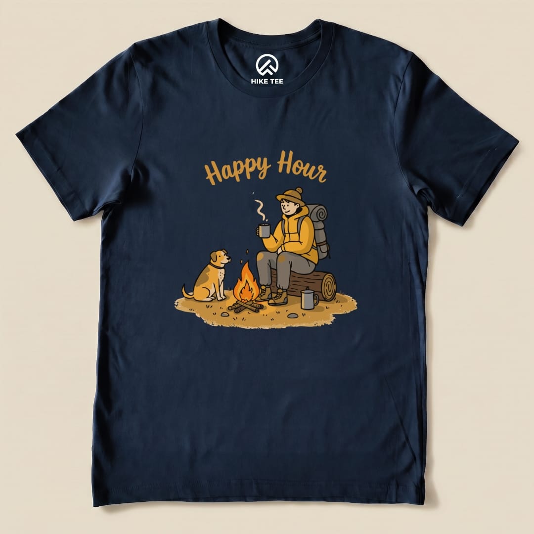 A navy graphic t-shirt featuring a campsite scene with a person enjoying coffee by a fire alongside a dog, labeled "Happy Hour.