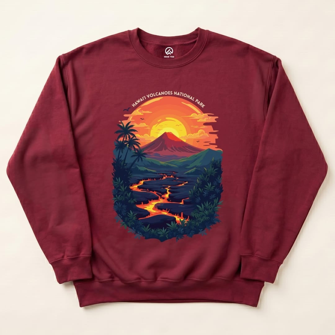A maroon sweatshirt featuring a colorful graphic of a volcano at sunset with "Hawai'i Volcanoes National Park" text above.