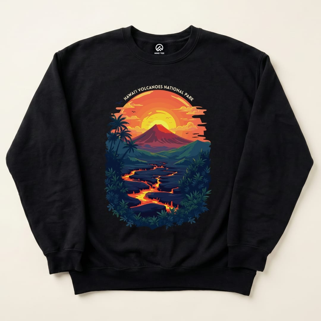 The image shows a black sweatshirt featuring a vibrant graphic of a volcano with a sunset and the text "Hawai'i Volcanoes National Park Sweatshirt.