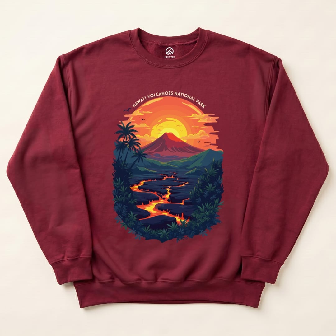 A maroon sweatshirt featuring a colorful graphic of a volcano at sunset with "Hawai'i Volcanoes National Park" text above.