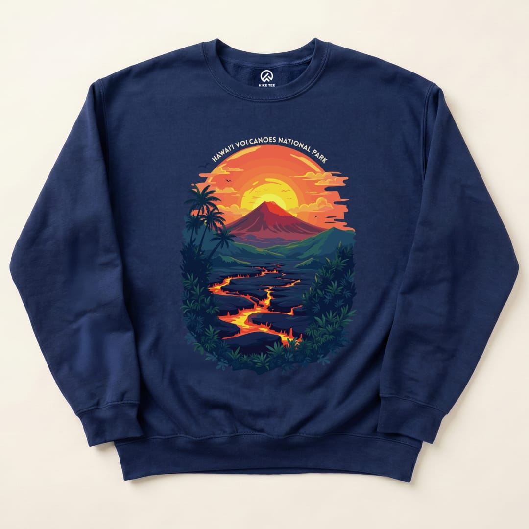 A navy sweatshirt featuring a vibrant graphic of a sunset over a volcano, with "Hawai'i Volcanoes National Park" text above.