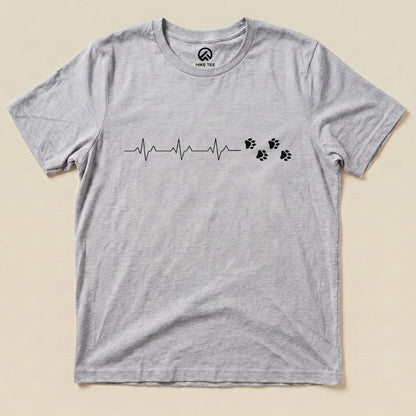 The Heart Beat Faws Shirt features a heartbeat line and animal paw prints printed on a heather gray graphic t-shirt.