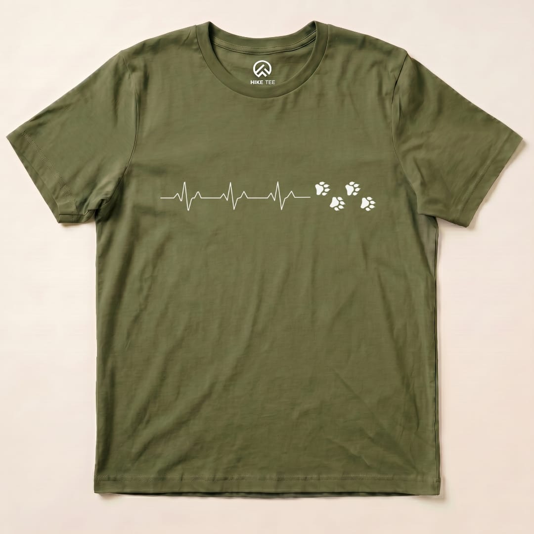 A flat olive green graphic t-shirt featuring a heartbeat line and paw prints, labeled as the "Heart Beat Faws Shirt.