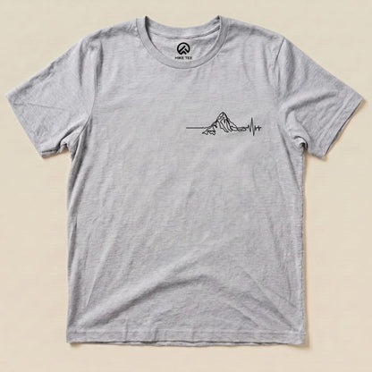 A light gray graphic t-shirt featuring a line art design of a mountain with a heartbeat line, labeled as the "Heart Rate Mountain Shirt.