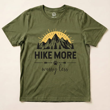The Hike More Worry Less Shirt features a graphic of mountains, a sun, and trees, with the slogan prominently displayed in black print.