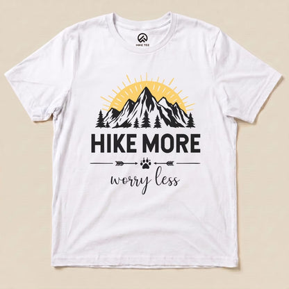 A graphic t-shirt featuring the slogan "Hike More Worry Less" above a mountain and sun design, set on a white background.
