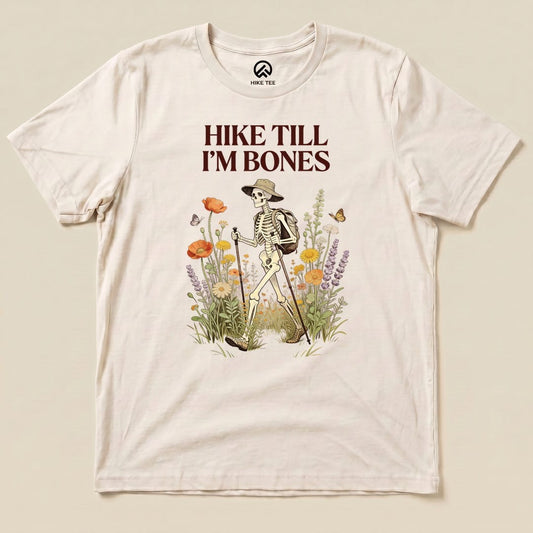 Natural Hike Till I'm Bones Shirt with a skeleton hiker walking through wildflowers graphic