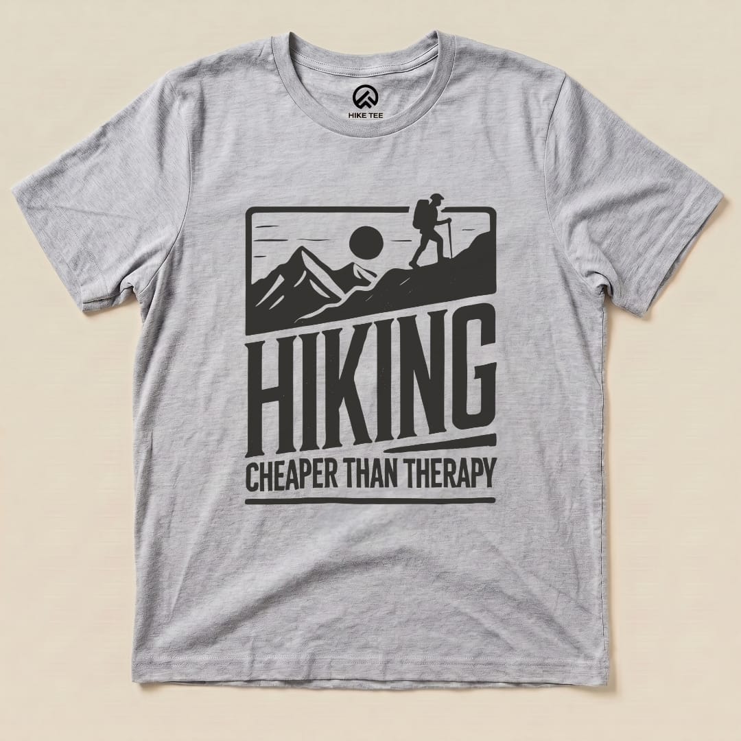 A gray graphic t-shirt features mountains, a hiker silhouette, and the slogan "Hiking Cheaper Than Therapy.
