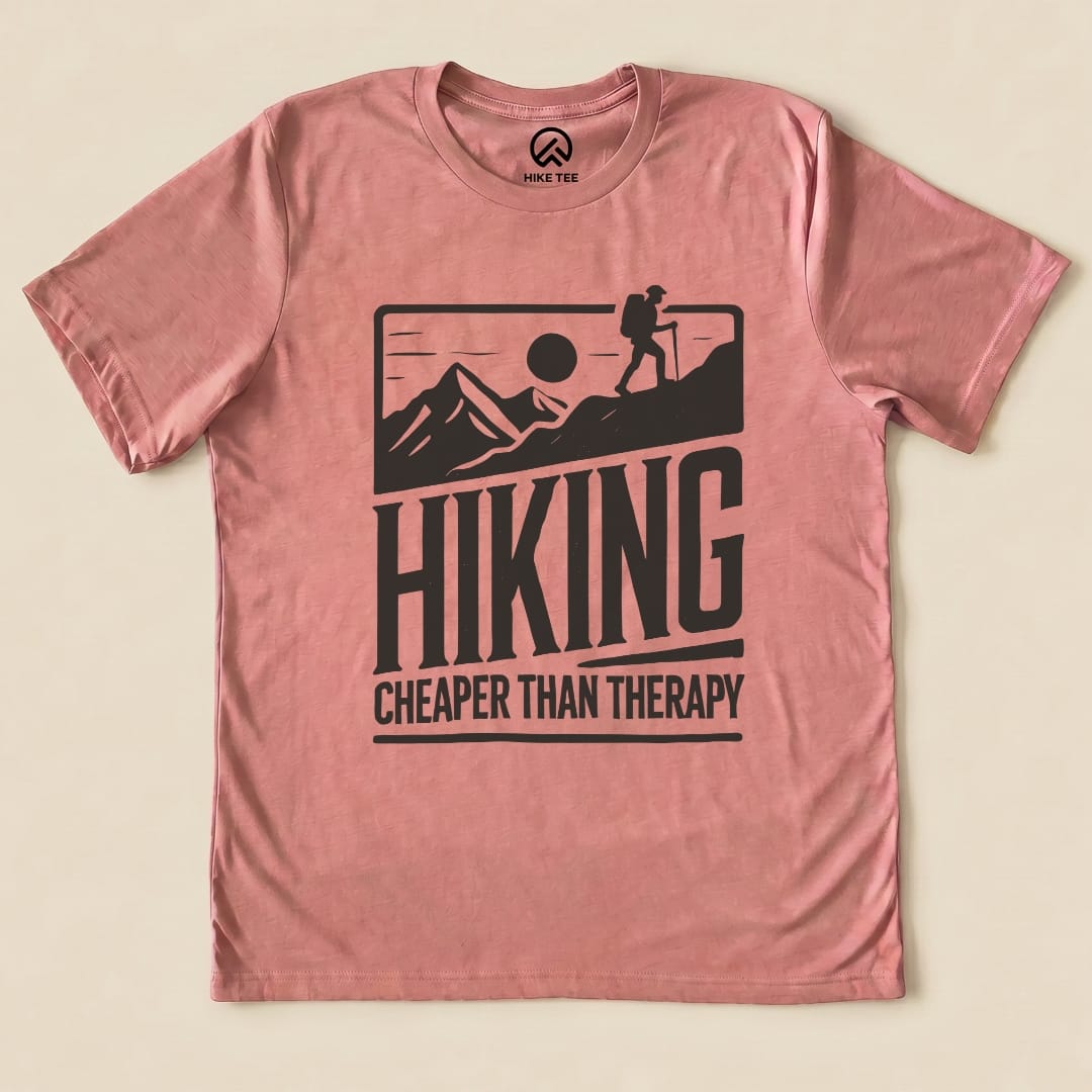 The graphic t-shirt displays the phrase "HIKING CHEAPER THAN THERAPY" alongside a silhouette of a hiker against mountain scenery.