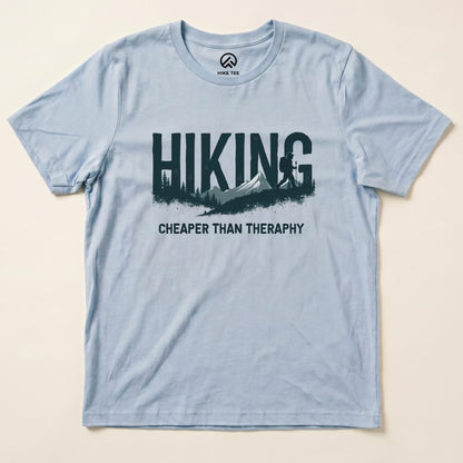 Light blue graphic t-shirt featuring the text "Hiking - Cheaper than Therapy" along with a mountain and forest design.