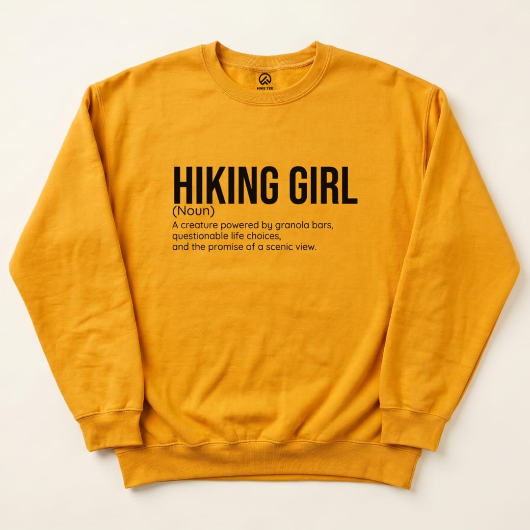 The Hiking Girl Definition Sweatshirt features bold typography defining a "Hiking Girl" humorously, set against a vibrant yellow backdrop.