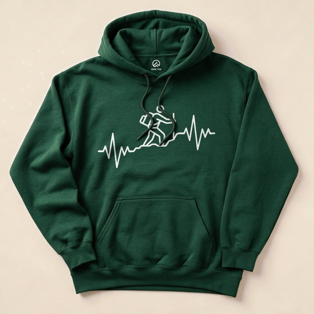 The dark green Hiking Heart Rate Hoodie features a graphic of a hiker climbing with a heartbeat line beneath it, showcasing a fun outdoor theme.