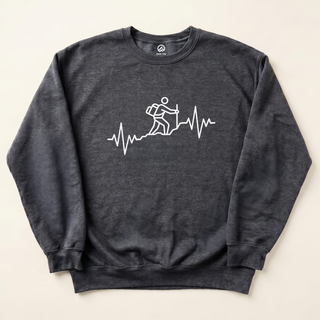 A gray graphic sweatshirt featuring a white design of a hiker climbing a mountain over a heartbeat line, labeled "Hiking Heart Rate Sweatshirt.