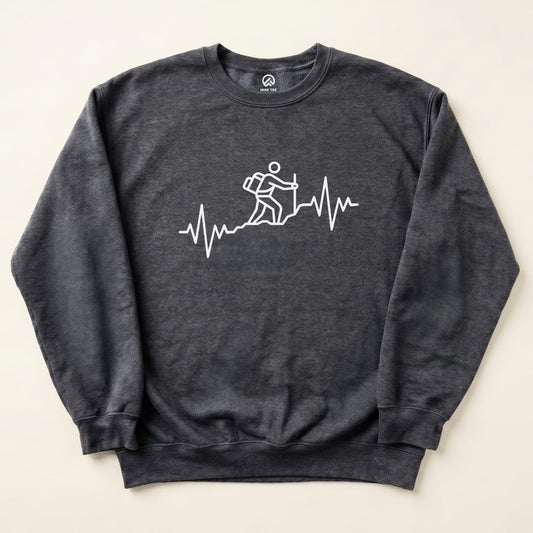 A gray graphic sweatshirt featuring a white design of a hiker climbing a mountain over a heartbeat line, labeled "Hiking Heart Rate Sweatshirt.