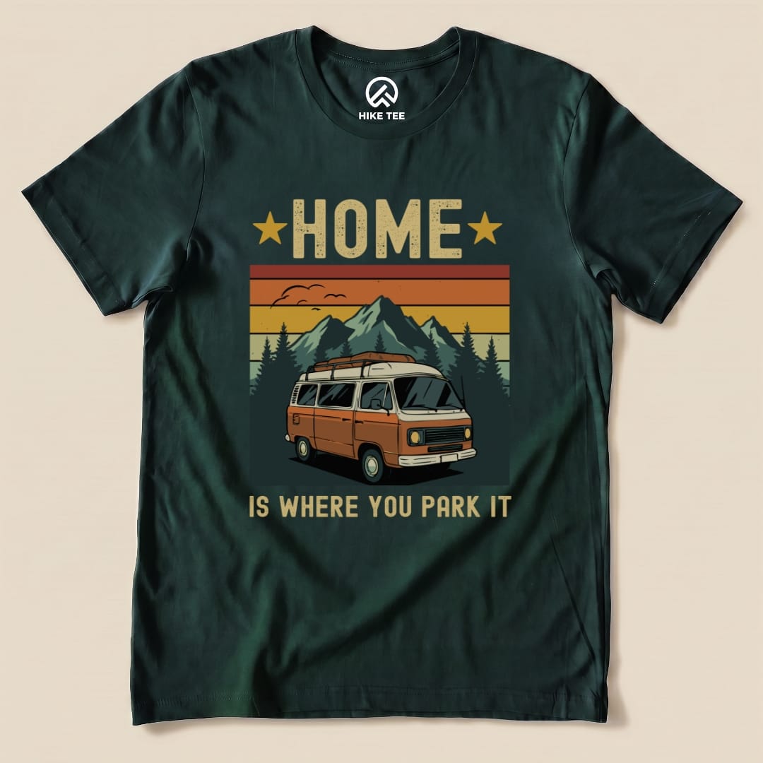 A graphic t-shirt featuring a retro-style orange van with the phrase "Home Is Where You Park It" above mountain scenery.