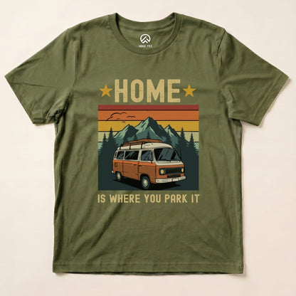 A graphic t-shirt in olive green featuring the slogan "HOME IS WHERE YOU PARK IT" and an illustration of a vintage orange van with mountains.