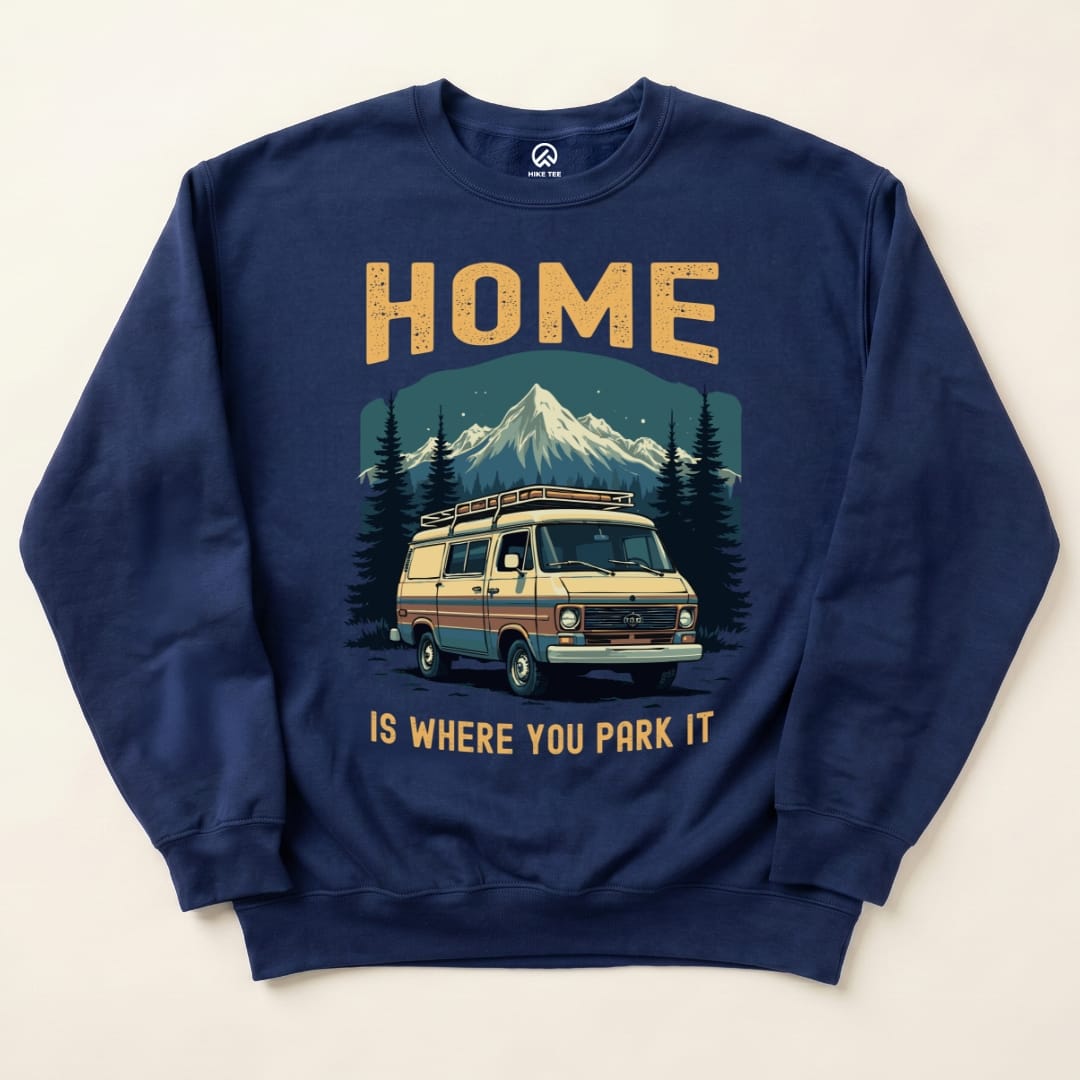 A navy blue "Home Parked Sweatshirt" featuring a graphic of a vintage van parked in front of mountains with the text "HOME IS WHERE YOU PARK IT.