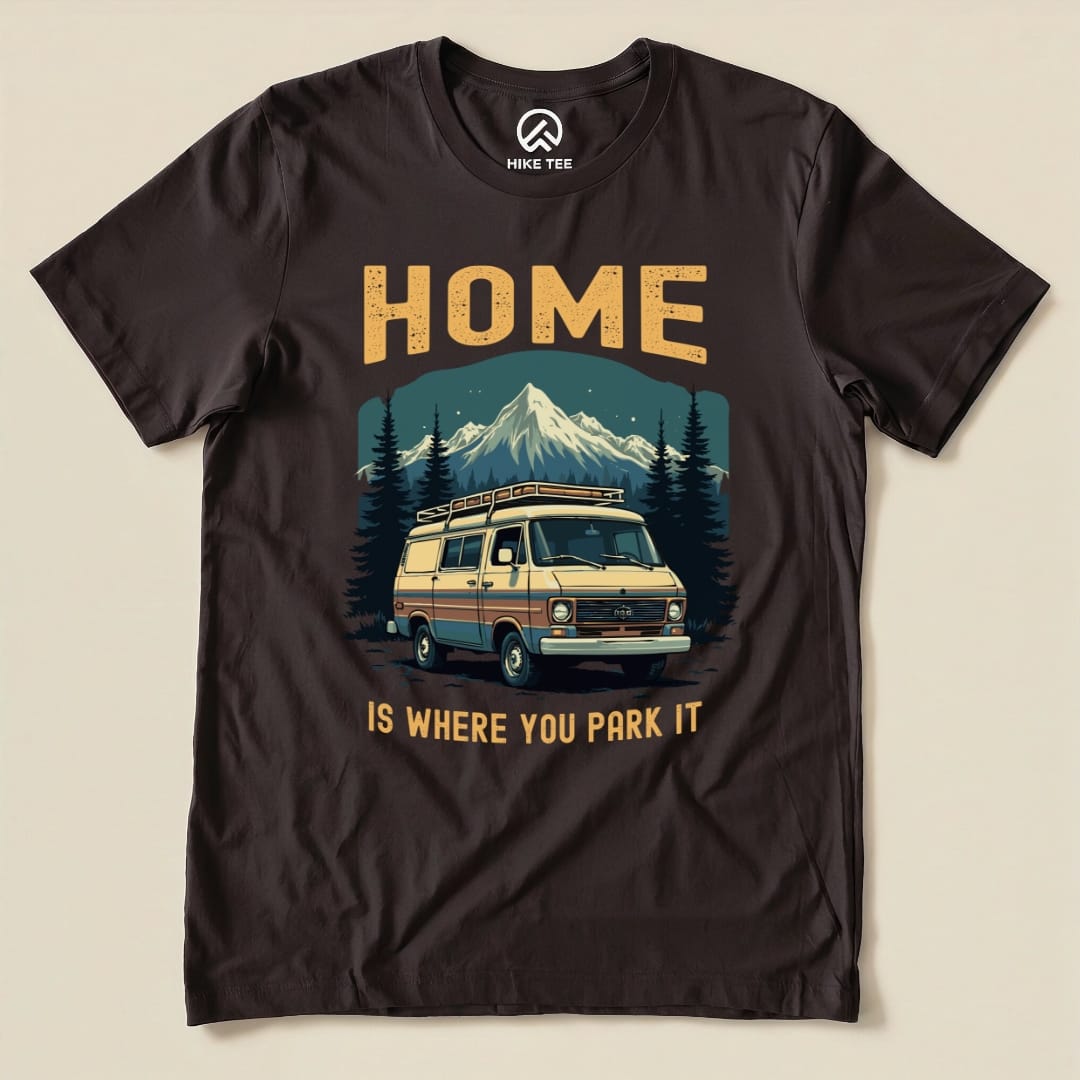 A graphic t-shirt featuring a vintage van, mountains, and the slogan "HOME IS WHERE YOU PARK IT," showcasing the Home You Park It Shirt design.