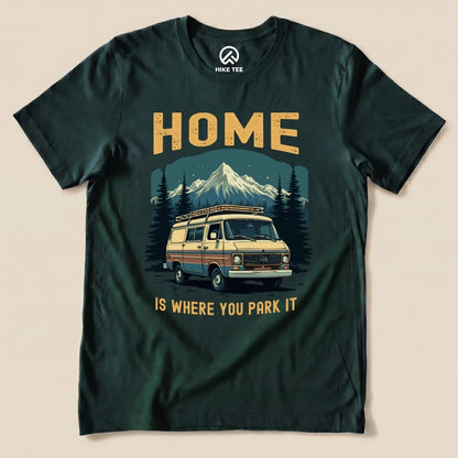 A graphic t-shirt featuring the phrase "Home Is Where You Park It" above an illustration of a vintage camper van and mountains.