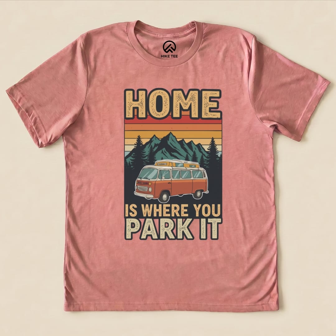 A pink graphic t-shirt displays the phrase "Home Is Where You Park It" alongside a vintage camper and mountains.