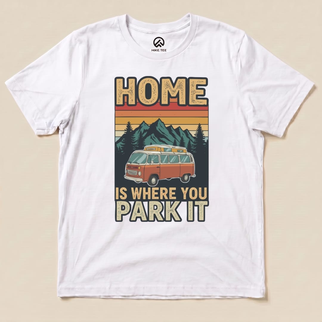 Graphic t-shirt featuring a vintage orange van set against mountains and trees, with the text "HOME IS WHERE YOU PARK IT.